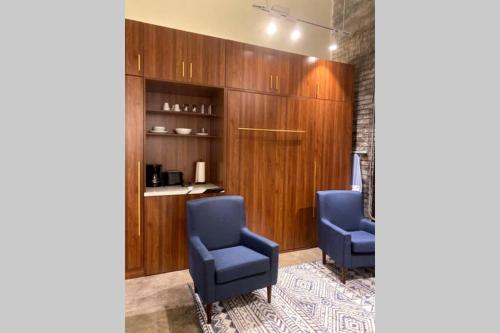 two blue chairs in a room with wooden cabinets at 3E-Cozy! Micro apartment minutes from Shadyside, sleeps 1 in Pittsburgh