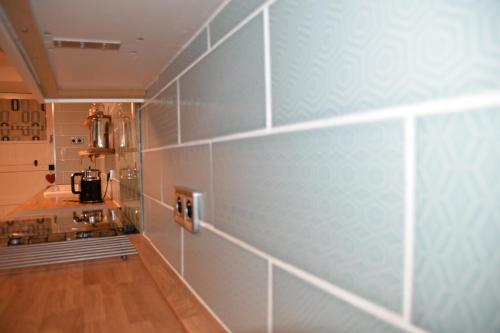 a kitchen with blue tiles on the wall at Le Breil Furet in Ménéac