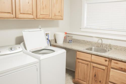 a white kitchen with a sink and a washing machine at Family Friendly Home - Utah Valley Sanctuary in Orem