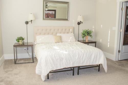 a bedroom with a white bed with two night tables at Family Friendly Home - Utah Valley Sanctuary in Orem