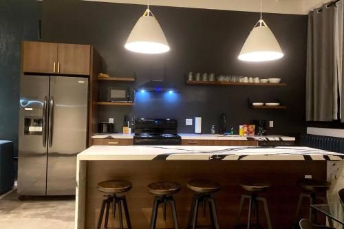 a kitchen with a counter with stools and a refrigerator at 3E-Spacious 2 bedroom in Oakland, sleeps 8 in Pittsburgh