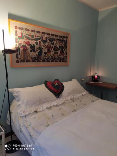 um quarto com uma cama e uma fotografia na parede em Locazione turistica VENTO del NORD em Tirano