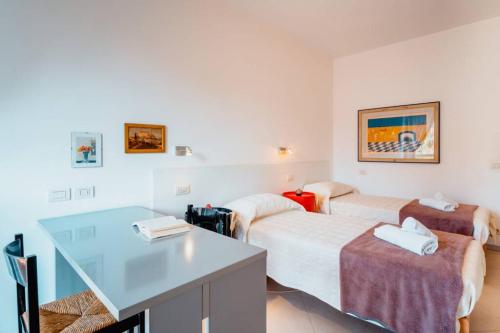a hotel room with two beds and a desk at Grand Central Ventimiglia - WiFi & Parking in Ventimiglia