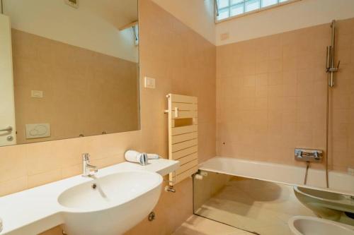 a bathroom with a sink and a mirror and a tub at Grand Central Ventimiglia - WiFi & Parking in Ventimiglia