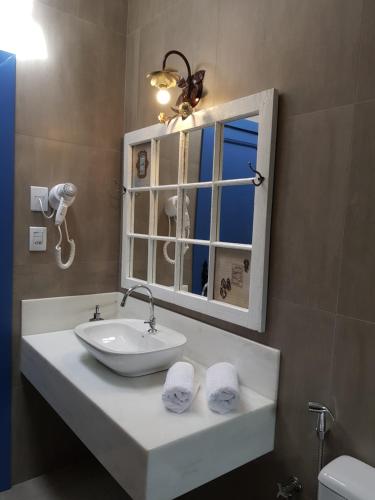 a bathroom with a sink and a mirror at Suite Tomaz Gonzaga in Ouro Preto