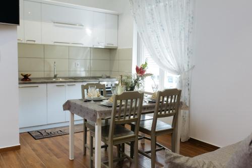 une cuisine et une salle à manger avec une table et des chaises dans l'établissement Apartmani Mikic, à Palić