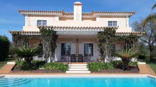 a house with a swimming pool in front of it at Villa Crisaflor in Moncarapacho