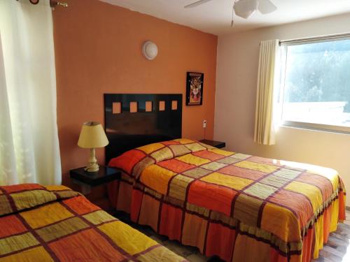 een slaapkamer met 2 bedden en een raam bij Gal - Habitaciones Confortables in Cuernavaca