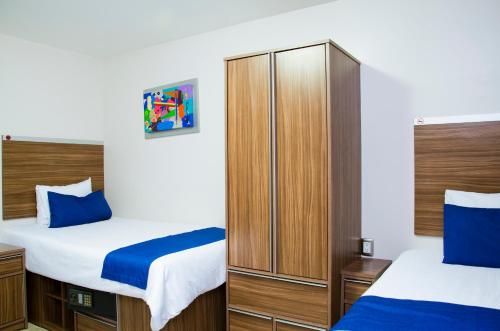 1 dormitorio con 2 camas y armario en La Casa Azul (Zona de Hospitales), en Ciudad de México