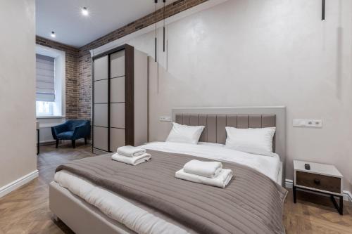 a bedroom with a large bed with two towels on it at Rynok Square apartment 2 in Lviv