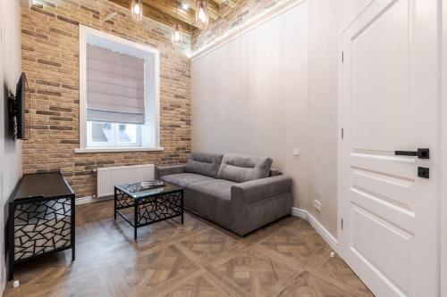 a living room with a couch and a brick wall at Rynok Square apartment 2 in Lviv