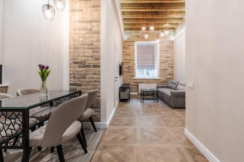 a dining room with a table and a brick wall at Rynok Square apartment 2 in Lviv