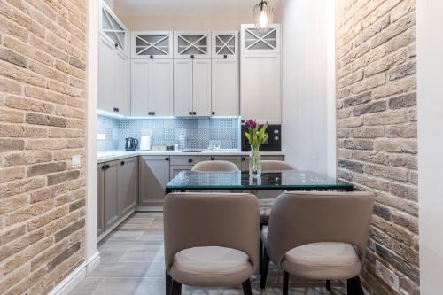 a kitchen with a table and chairs and a brick wall at Rynok Square apartment 2 in Lviv