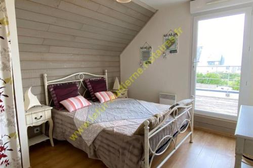 a bedroom with a bed and a large window at MAISON DE VACANCES, A 150 m de la Mer in Plouhinec