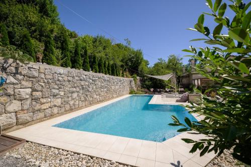 una piscina junto a una pared de piedra en Boutique B&B Mali Pariz, en Crikvenica