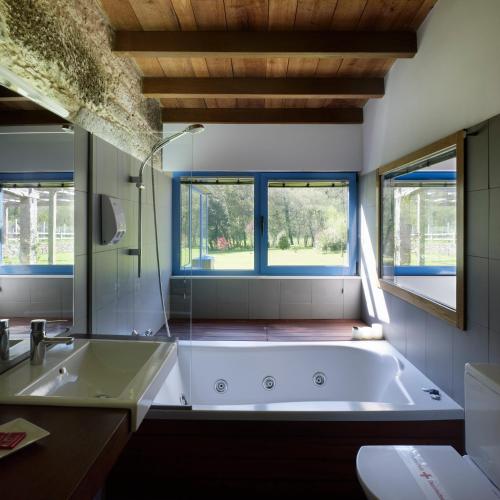 a bathroom with a large tub and a window at A Cabana de Carmen in Cabana Moura 