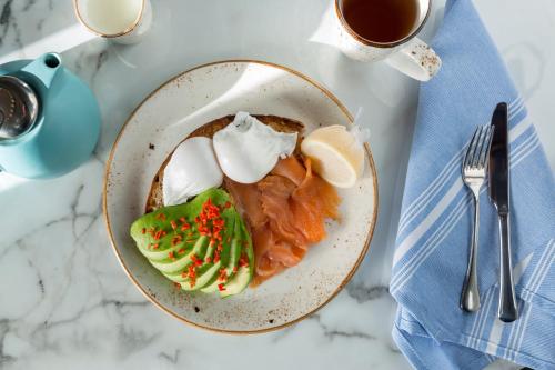 a plate of food on a table with a cup of coffee at Hotel Indigo - Cardiff by IHG in Cardiff