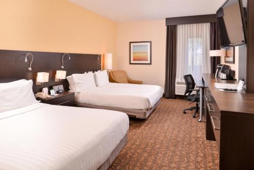 una camera d'albergo con due letti e una scrivania di Holiday Inn Express & Suites Topeka West I-70 Wanamaker by IHG a Topeka