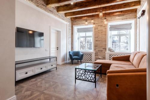 Una sala de estar con un sofá y un televisor. en View on Rynok Square apartments, en Leópolis