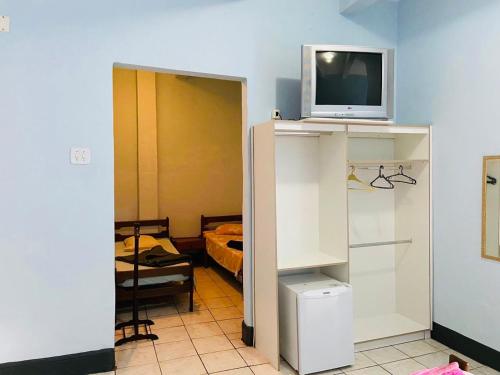 a room with a tv on top of a cabinet at Hotel Planalto in Poços de Caldas