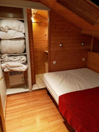 1 dormitorio con 2 camas en una habitación con paredes de madera en Duplex de 65 m² à l'esprit chalet, en La Bourboule