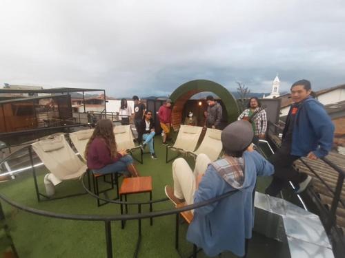 a group of people sitting in chairs on a roof at Ñañas Hostel in Cuenca