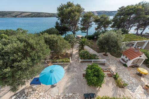 una vista aérea de un patio con una sombrilla azul en Apartments Jadra - 28 m from beach, en Stara Novalja