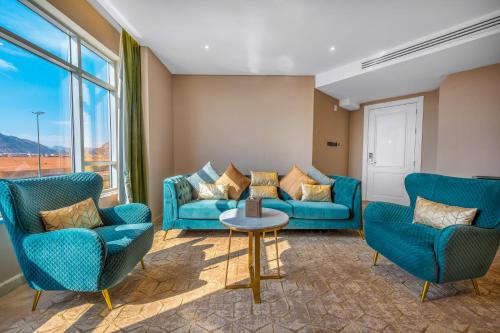 a living room with blue couches and a table at Suknai Royal Hotel in Hail
