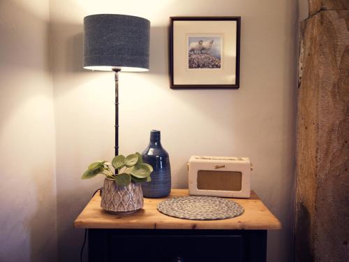 a table with a lamp a vase and a microwave at West House in Middleton in Teesdale