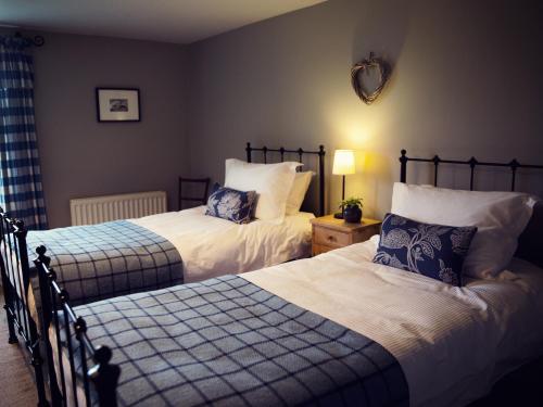 a bedroom with two beds and a mirror on the wall at West House in Middleton in Teesdale