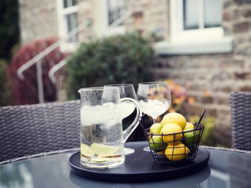 a table with two glasses of water and a basket of lemons at West House in Middleton in Teesdale