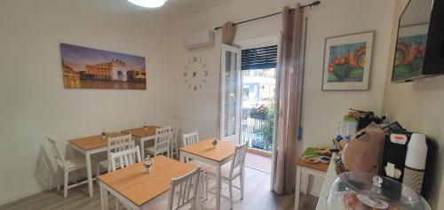 a dining room with tables and chairs and a window at B&B Carpe Diem in Palermo