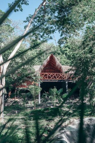 a building in the middle of a forest with trees at Refugio Monte Oscuro in Las Mercedes