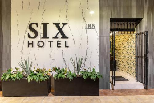 a hotel entrance with plants in front of a hotel at Six Hotel Guadalajara Degollado in Guadalajara