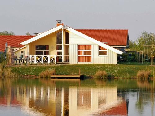 une maison à côté d'une masse d'eau dans l'établissement 12 person holiday home in Otterndorf, à Otterndorf