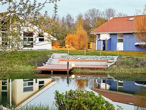 a house and a dock on a lake at 12 person holiday home in Otterndorf in Otterndorf