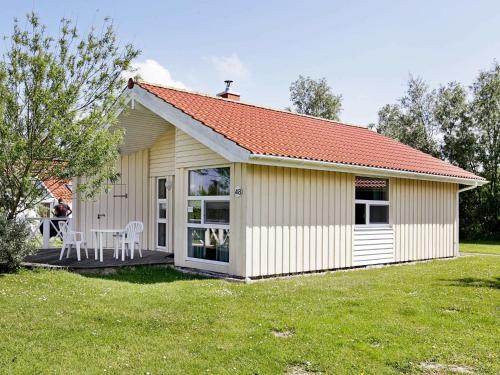 ein kleines Haus mit einem Tisch und Stühlen im Hof in der Unterkunft 4 person holiday home in Otterndorf in Otterndorf