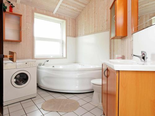 ein Badezimmer mit einer Badewanne, einem WC und einem Waschbecken in der Unterkunft Four-Bedroom Holiday home in Otterndorf 2 in Otterndorf