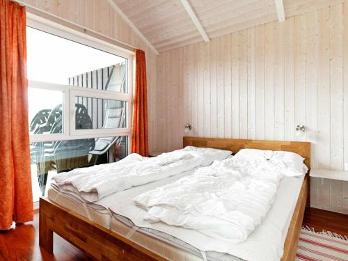 Bett in einem Zimmer mit einem großen Fenster in der Unterkunft Four-Bedroom Holiday home in Otterndorf 2 in Otterndorf