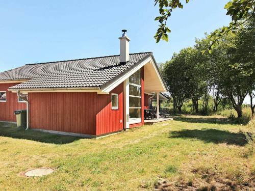 una casa roja con una ventana y un patio de césped en 8 person holiday home in Gro enbrode, en Großenbrode
