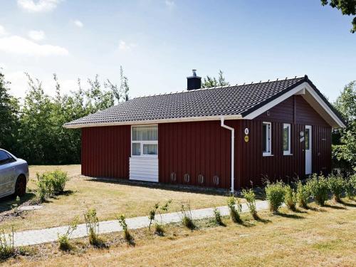 ein roter Schuppen mit einem davor geparkt in der Unterkunft 6 person holiday home in GROEMITZ in Grömitz