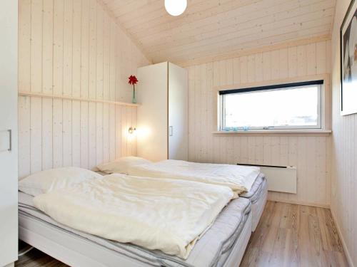 um quarto com 2 camas num quarto com uma janela em Three-Bedroom Holiday home in Großenbrode 8 em Grossenbrode