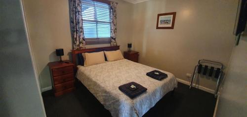 a small bedroom with a bed and a window at Sustainable B&B by the Bay in Brisbane