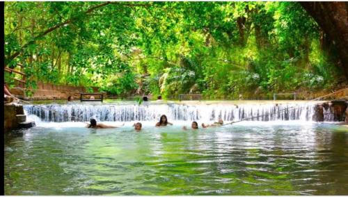 a group of people swimming in a waterfall at Rio Quente Aguas da Serra Apart in Rio Quente