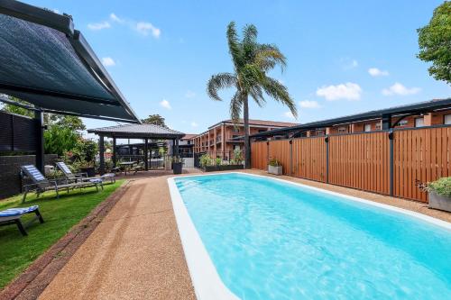 a swimming pool in the backyard of a house at Bluegum Dubbo Motel in Dubbo