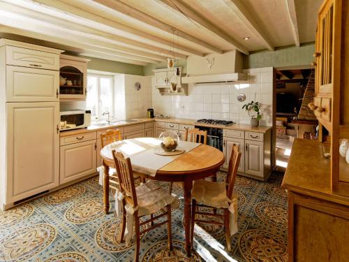 eine Küche mit einem Holztisch und Stühlen in der Unterkunft Charming cottage in a farm with views in Gimnée
