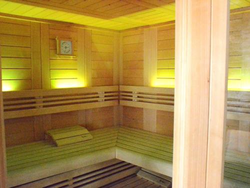 a sauna with a bench and a clock in it at Villa with hot tub and sauna in Bièvre