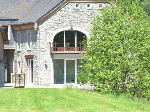 a brick house with a balcony on the side of it at Authentic Mill for Groups in Vencimont