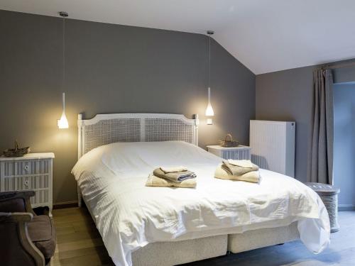 a bedroom with a white bed with two towels on it at Authentic Mill for Groups in Vencimont