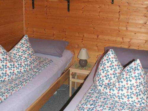 ein Schlafzimmer mit 2 Betten und einer Lampe auf einem Tisch in der Unterkunft Pretty Bungalow in Neubukow with Garden, Roof Terrace, BBQ in Neubukow